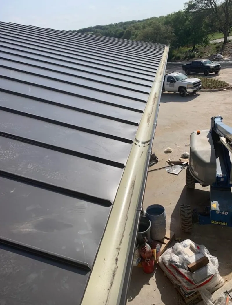 Standing seam panel and gutter detail on a metal roofing jobsite in Dalton